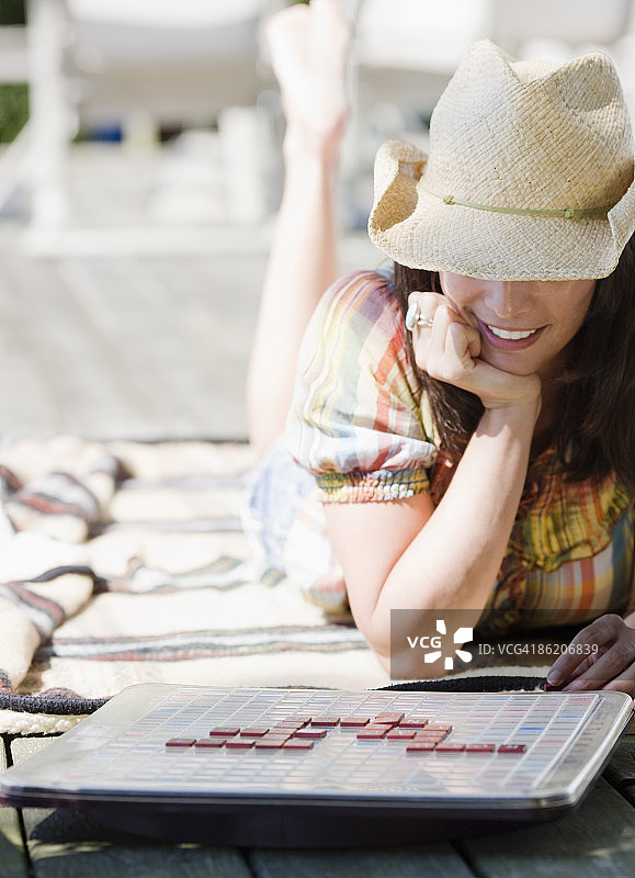 女人在甲板上玩拼字游戏图片素材