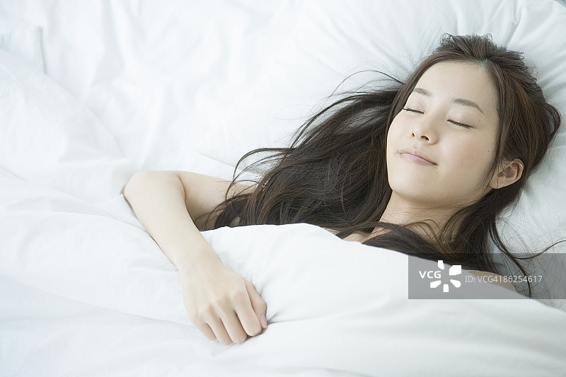 年轻女人在床上睡觉，肖像图片素材