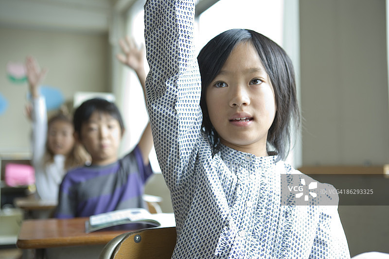 在教室里举手的女学生（8-9岁）图片素材