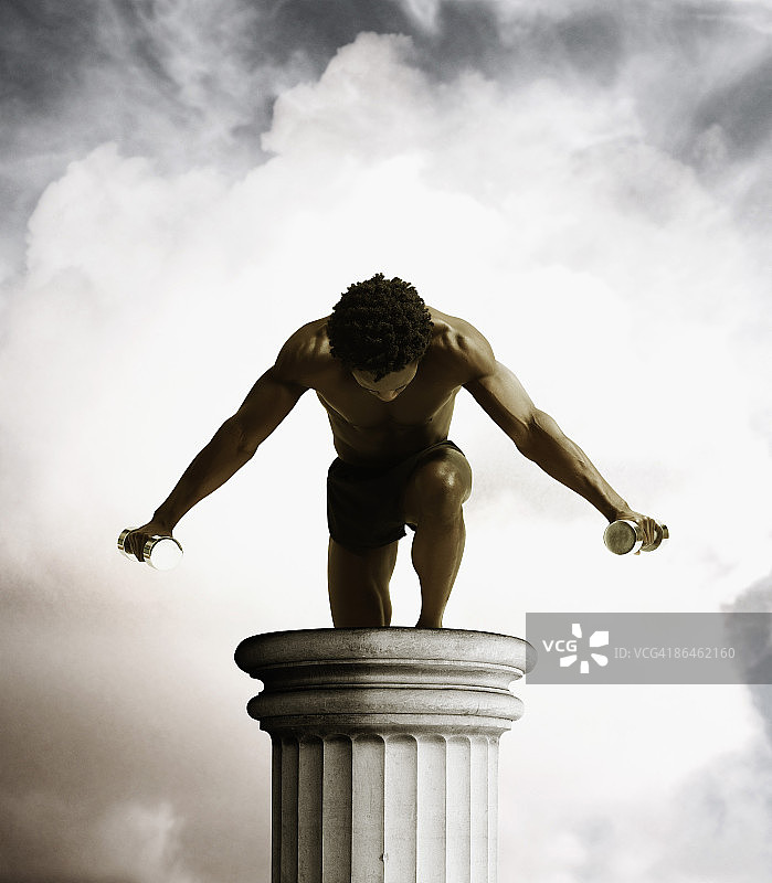 男人站在柱子上举哑铃图片素材