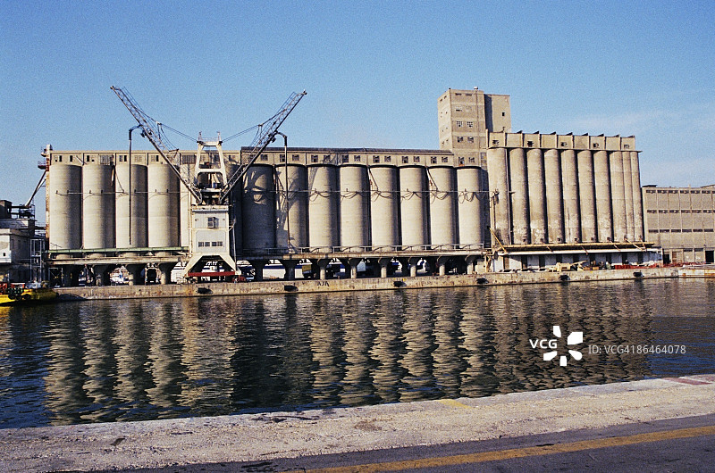 意大利奇维塔韦基亚的河流中倒映的工厂图片素材