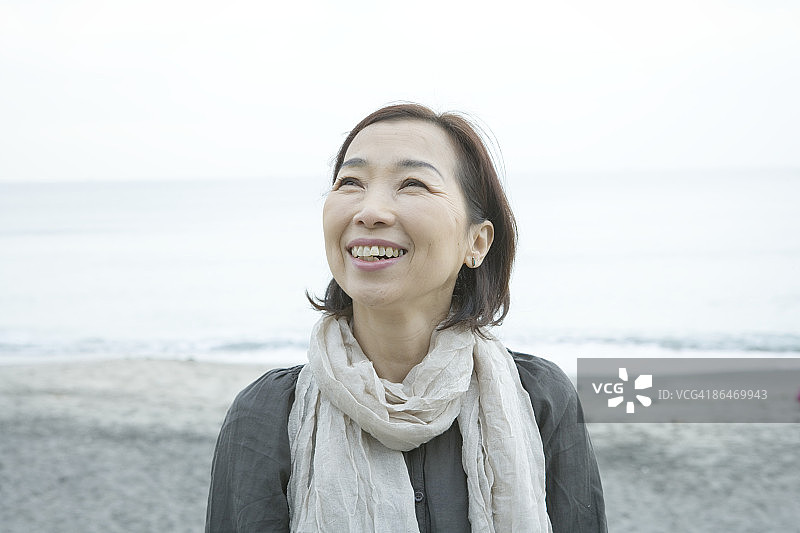 在海滩上抬头微笑的中年妇女图片素材