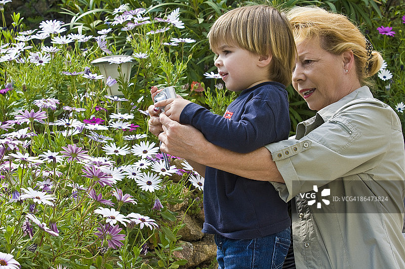 祖母帮助孙子拍照图片素材