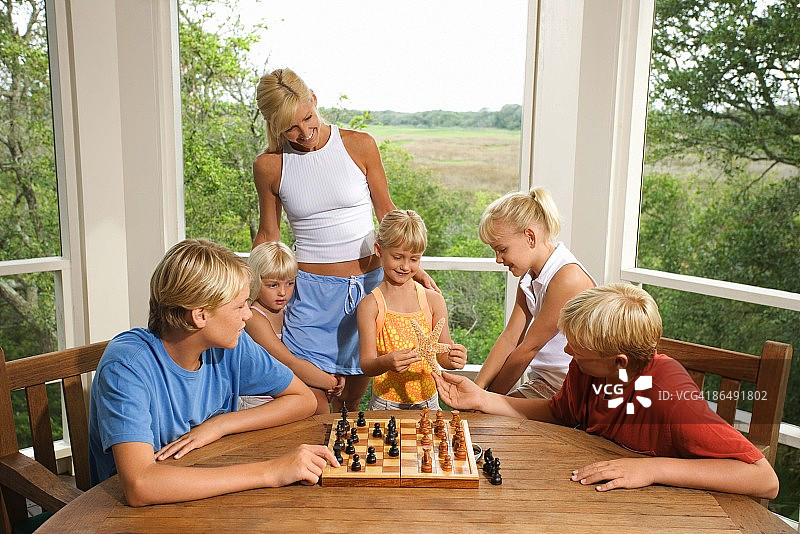 一家人观看男孩们下棋图片素材
