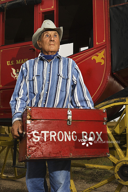 男人在驿站马车附近拿着保险箱图片素材