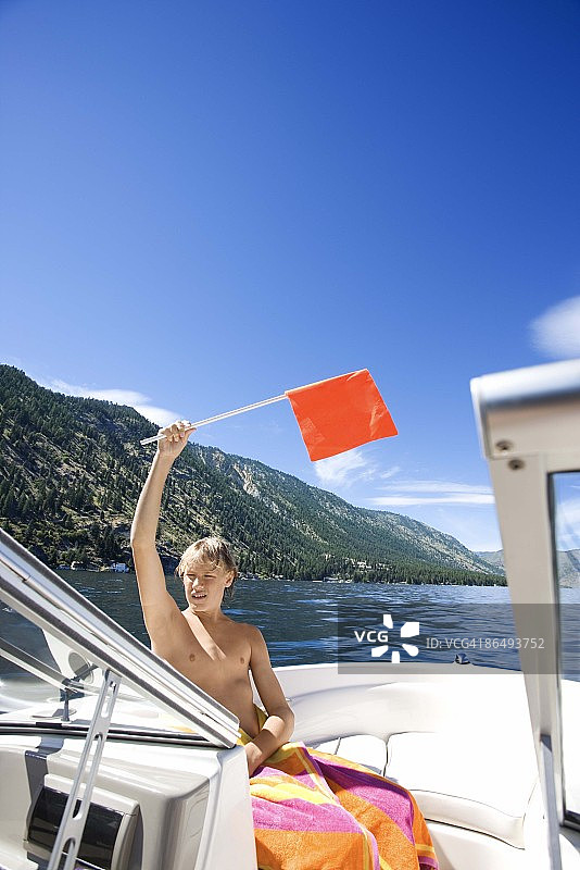 在船上挥舞红旗的男孩图片素材