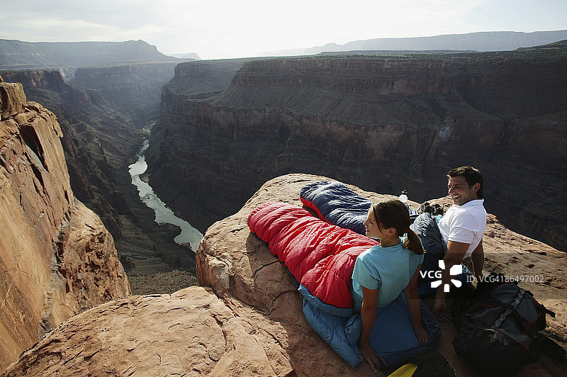 睡袋情侣在峡谷悬崖上图片素材