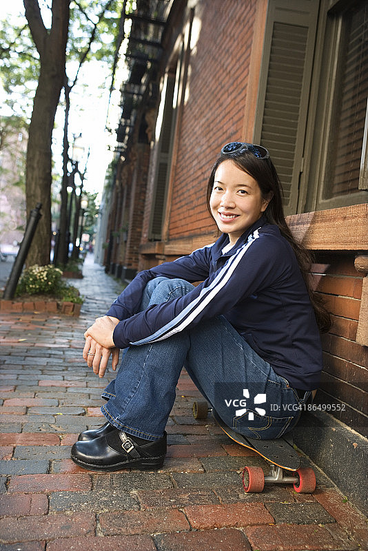 女人坐在滑板上图片素材