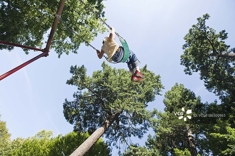 在公园荡秋千的女孩仰视图图片素材