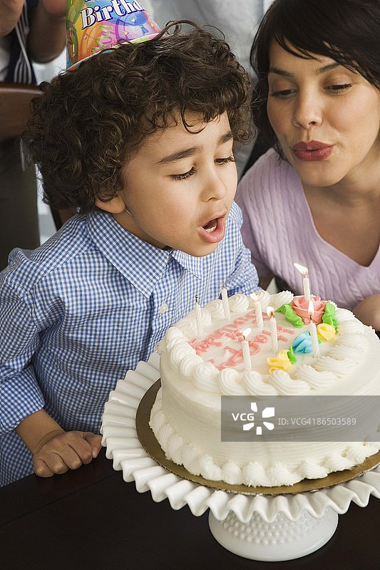 男孩吹灭生日蜡烛图片素材