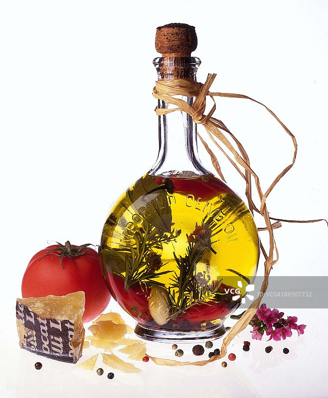 一瓶橄榄油，配以香草、奶酪和番茄图片素材