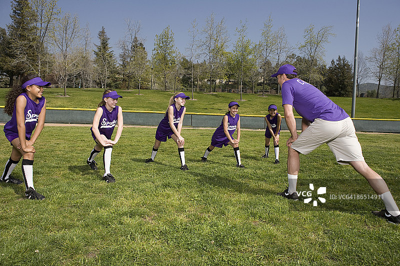 教练和小联盟球员伸展运动图片素材