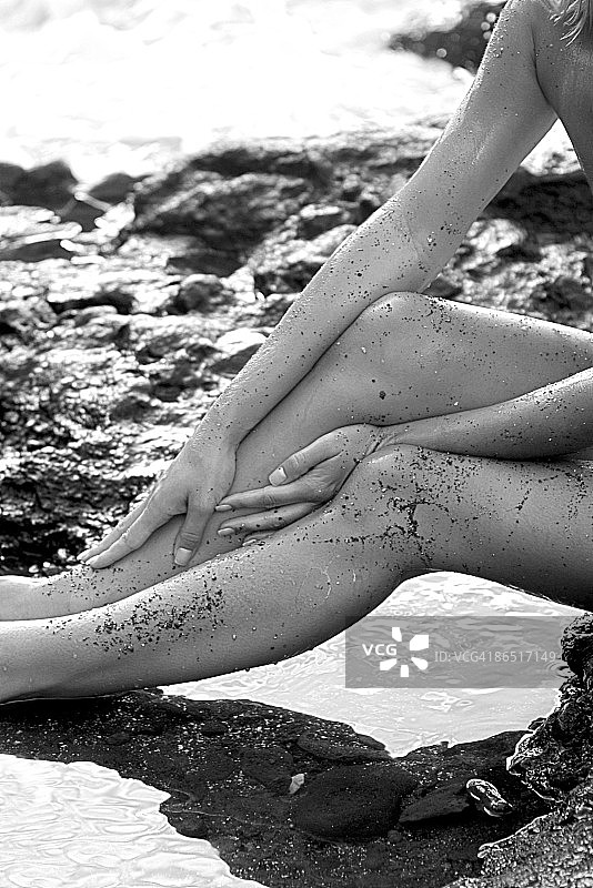 海滩上的女人手臂和腿图片素材