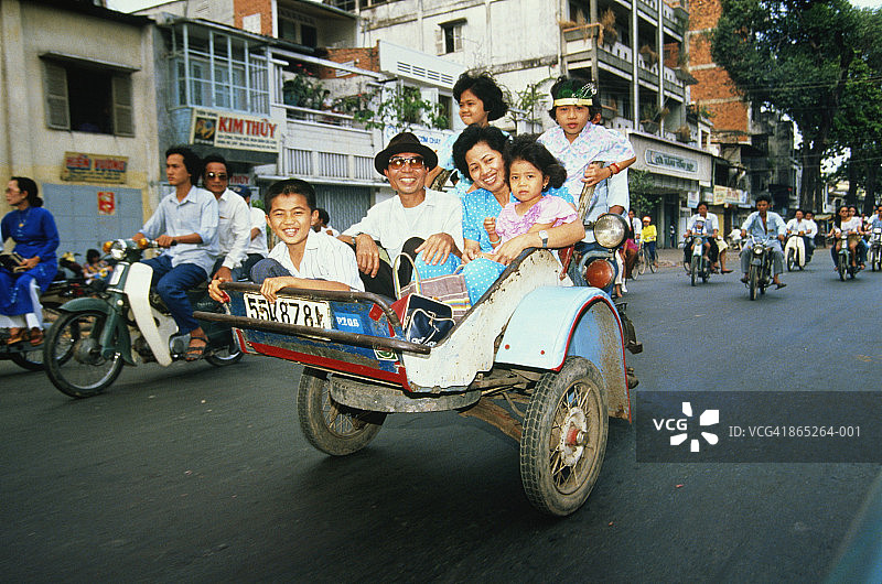 越南胡志明市：乘坐机动三轮车的家庭图片素材