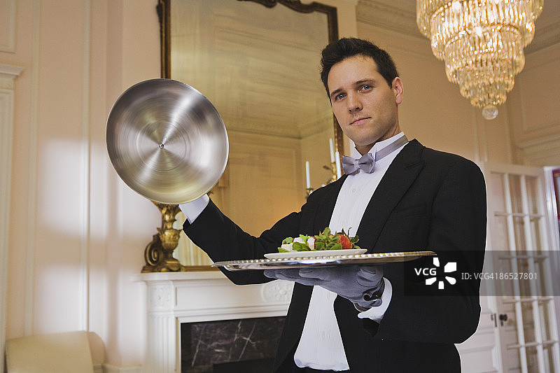 管家从托盘上揭开盖子图片素材