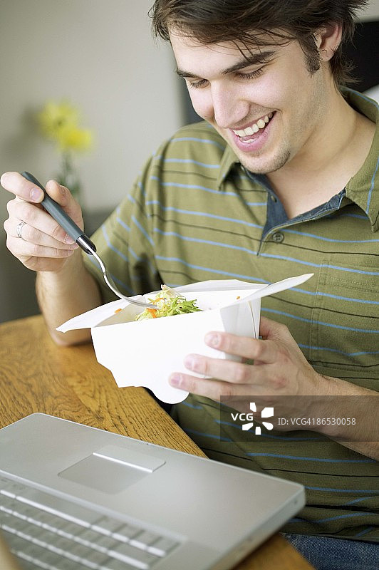 男人在电脑桌旁吃东西图片素材