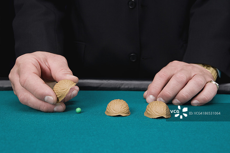 玩着贝壳和豌豆游戏的男人图片素材