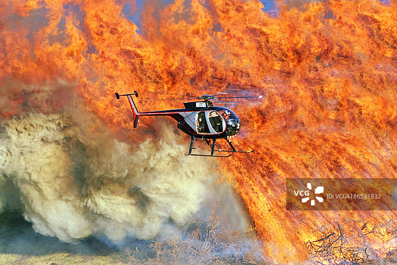 飞越灌木丛火灾的直升机图片素材