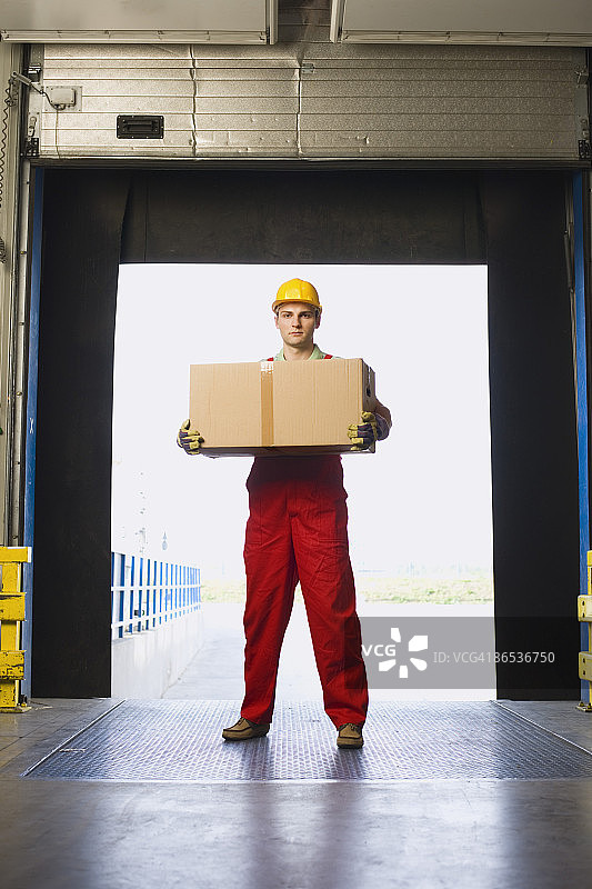戴着安全帽的工厂工人拿着盒子图片素材