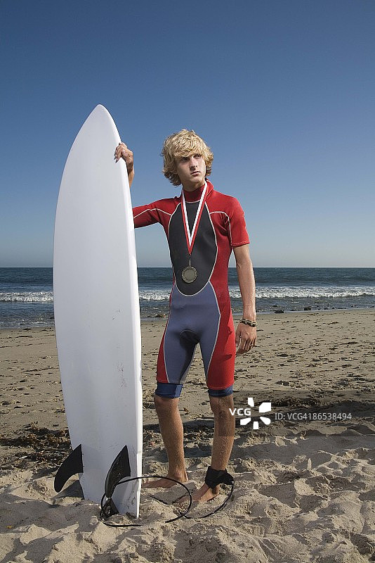 海滩上拿着冲浪板的青少年男孩图片素材