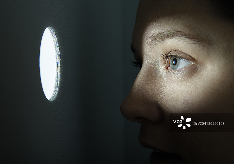 透过照明孔窥视的女人图片素材