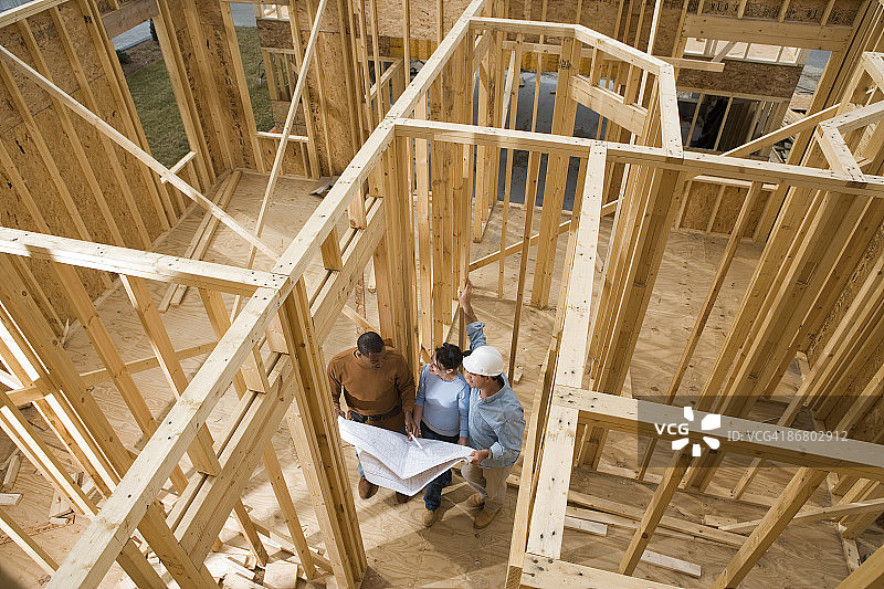 建筑师在建筑工地使用蓝图图片素材