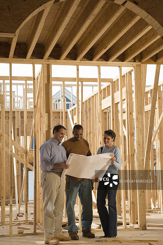 建筑师在建筑工地使用蓝图图片素材