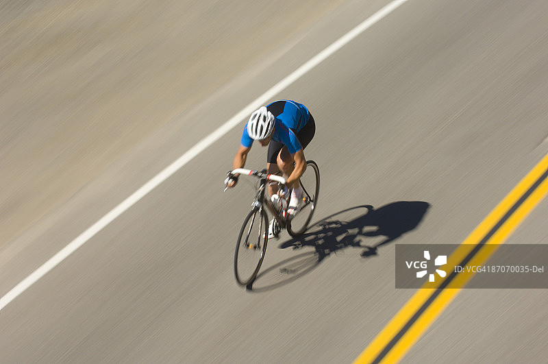 男人在加利福尼亚州特拉基的唐纳山口路上骑公路自行车图片素材