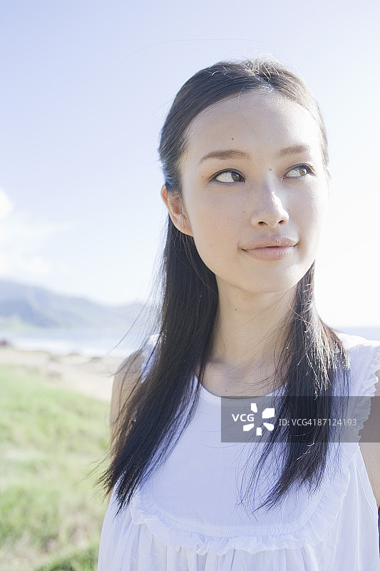 在海滩上眺望远方的年轻女子图片素材