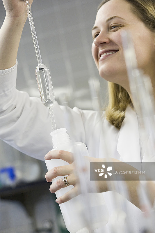 女科学家用容量移液管移取去离子水图片素材
