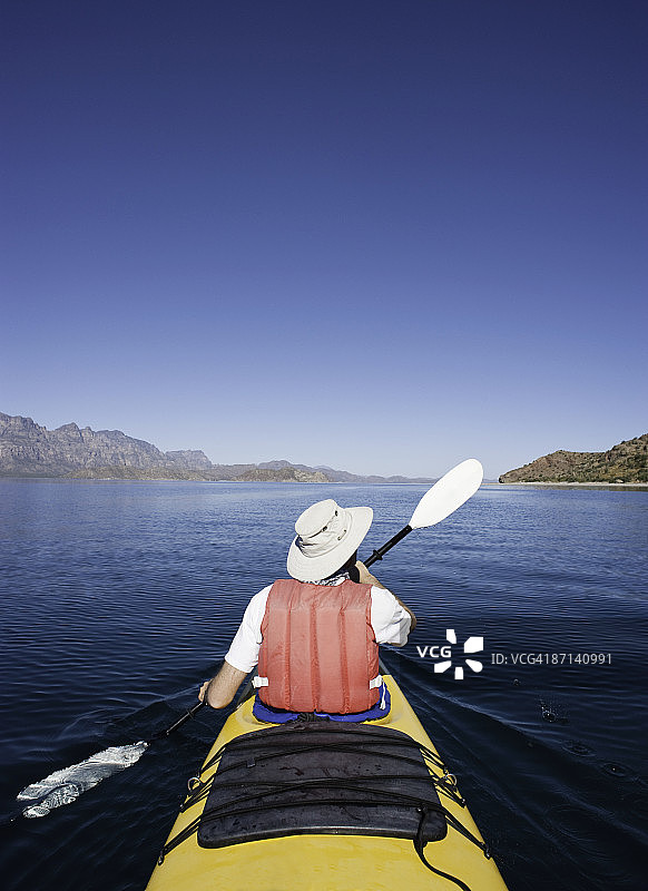 中年男人划着海上皮划艇图片素材