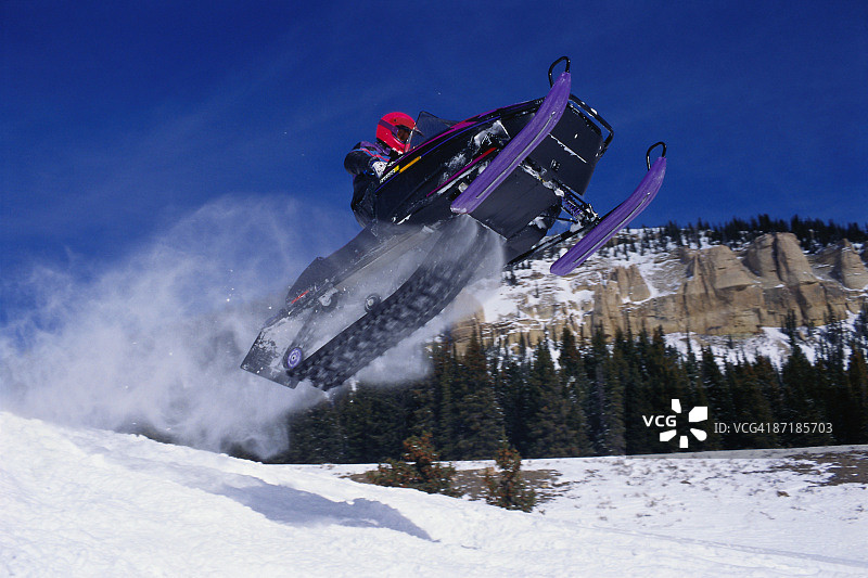 男子骑雪地摩托穿越怀俄明州大角山脉图片素材