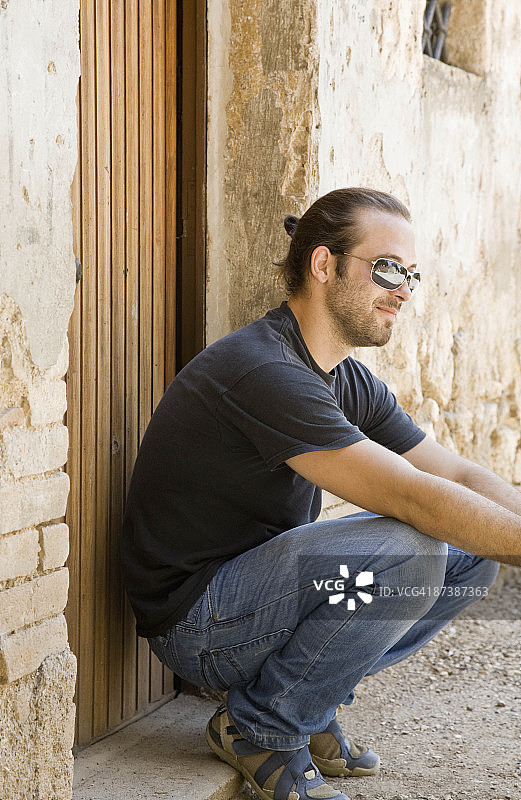 男子蹲在门口图片素材