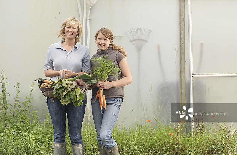 母亲和女儿拿着蔬菜图片素材