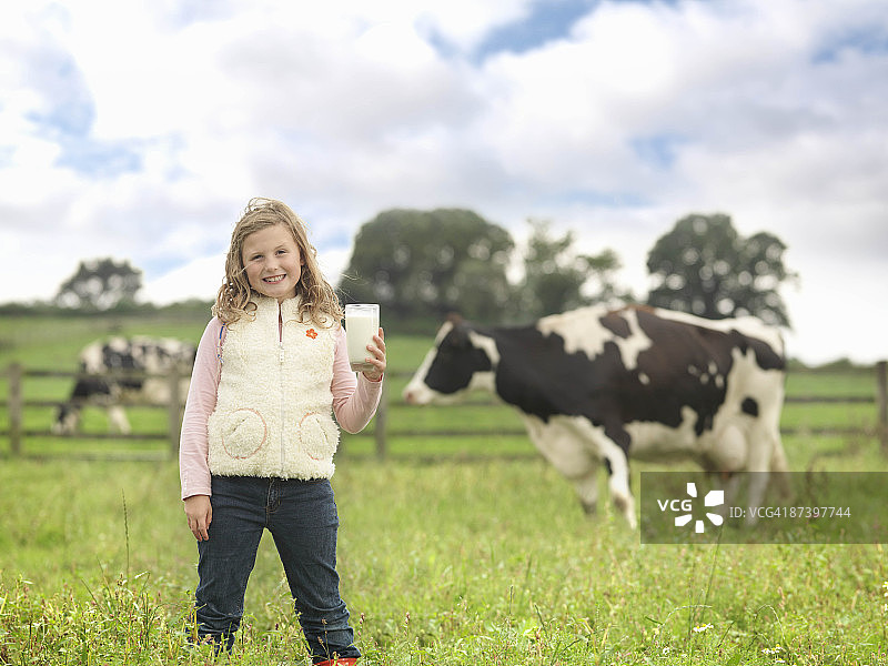 手拿牛奶和奶牛的女孩图片素材