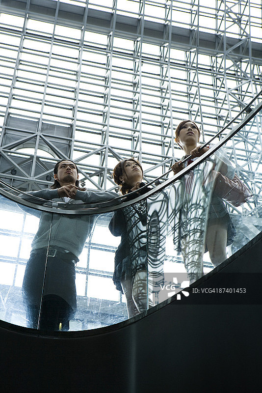 朋友们倚靠在栏杆上，抬头仰望图片素材