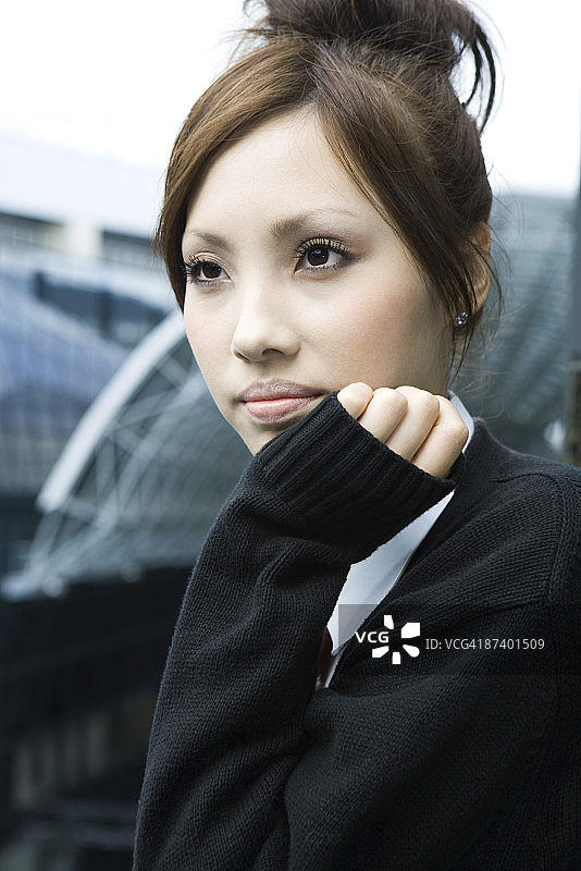 年轻女子看向远方，手托下巴，肖像图片素材