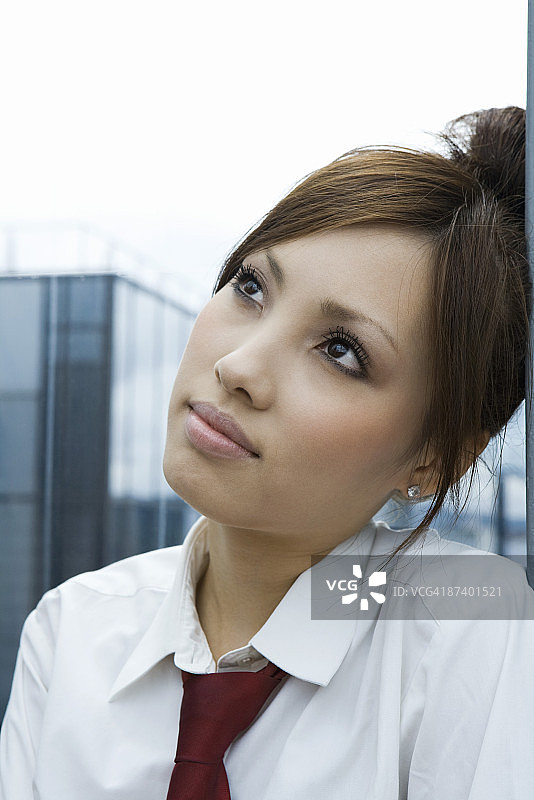 年轻女人靠墙抬头看，特写图片素材