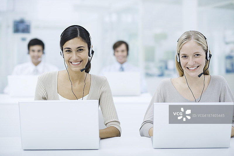电话销售员在呼叫中心工作，面带微笑图片素材