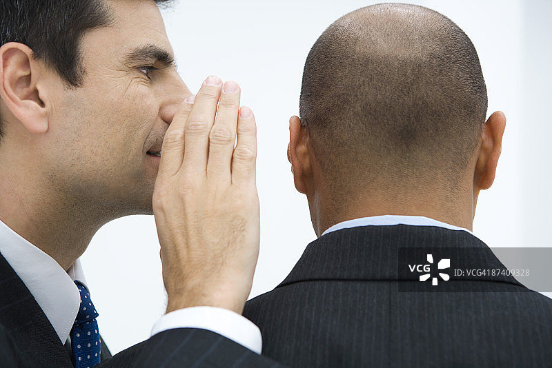 商务人士在同事耳边低语特写图片素材