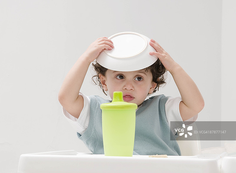 头顶着饭碗的男孩图片素材