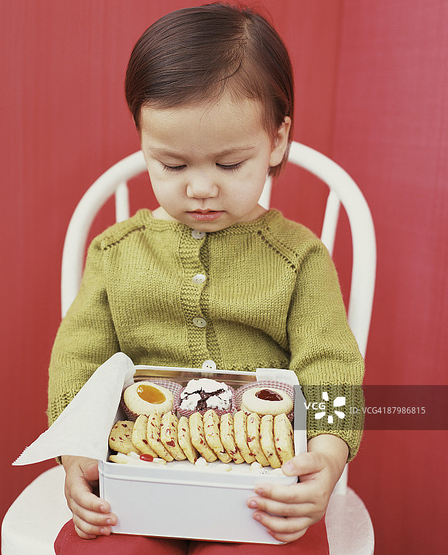 拿着一盒饼干的女孩图片素材