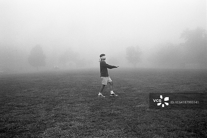 在雾中行走的蒙眼男人图片素材