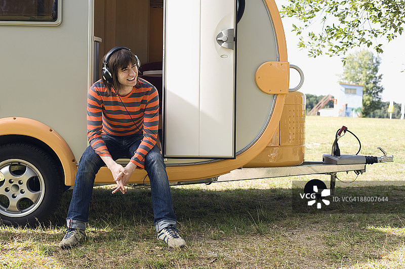 德国莱比锡阿梅尔斯海纳湖，戴着耳机听音乐的年轻男人图片素材