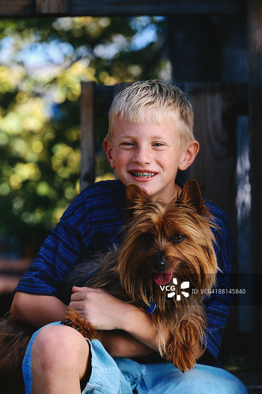 男孩抱着柔滑梗犬图片素材