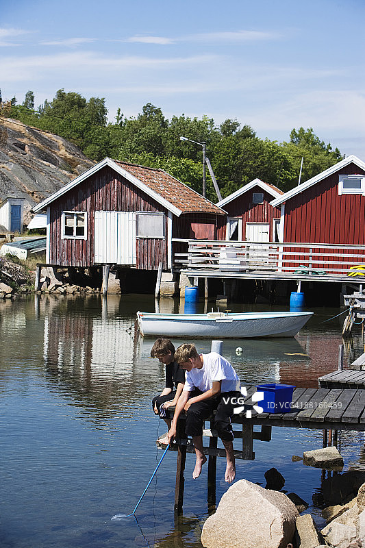两个男孩在瑞典博胡斯兰斯莫根钓鱼图片素材