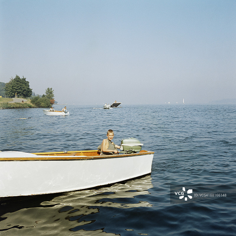 穿着救生衣在湖上划船的男孩图片素材
