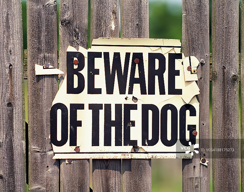 围栏上破旧的“当心恶犬”标志图片素材