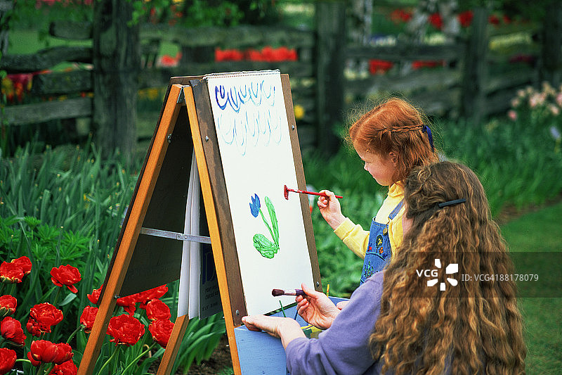 母女在花丛旁绘画图片素材