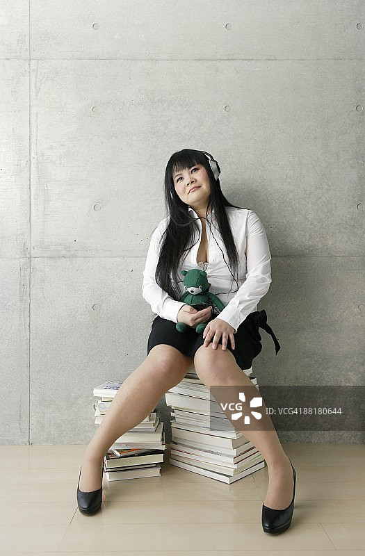 在书本上听音乐的胖女商人图片素材
